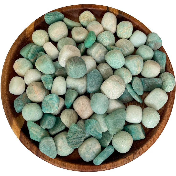 A pile of Amazonite stones on a wooden plate.