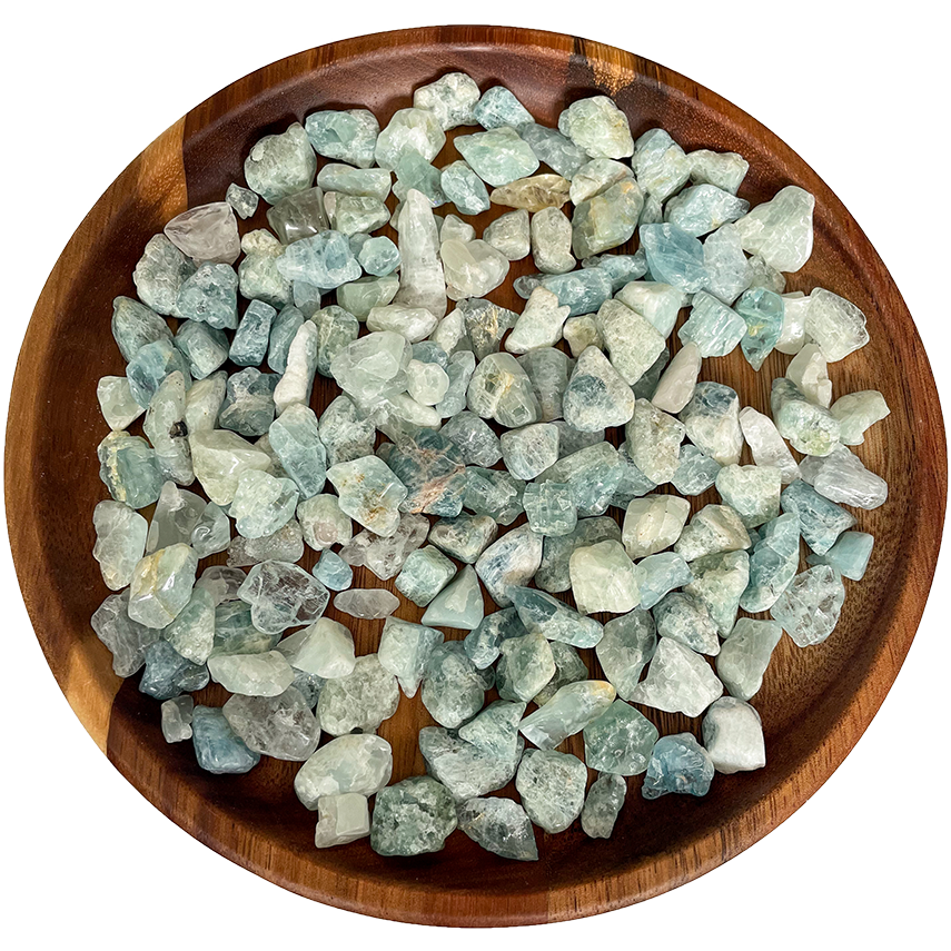 A collection of small aquamarine pieces on a wooden plate.