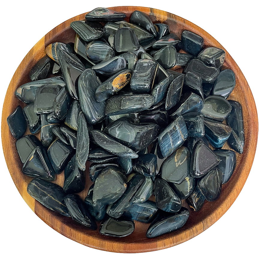 A collection of blue tiger's eye crystals on a wooden plate.