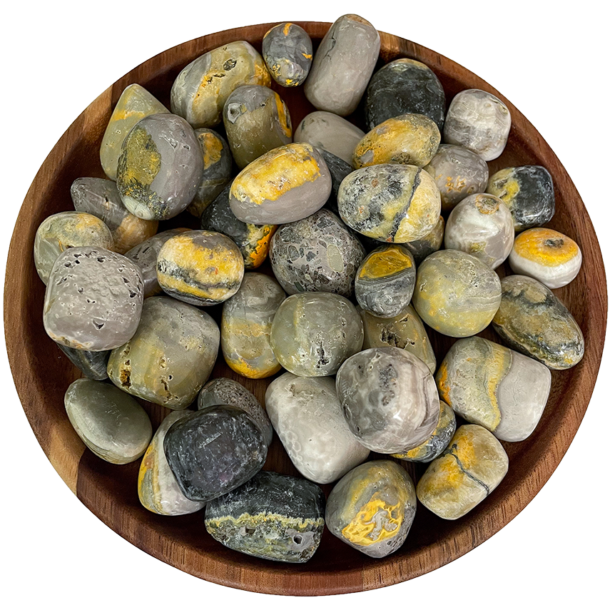A collection of bumble bee jasper stones on a wooden plate.