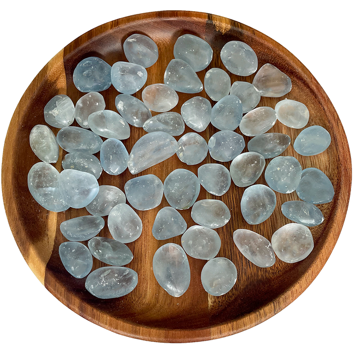 A collection of celestite crystals on a wooden plate.