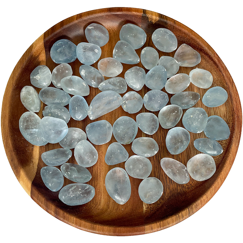 A collection of celestite crystals on a wooden plate.