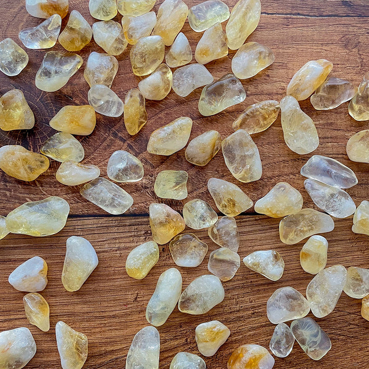 A handful of citrine stones on a wooden background.