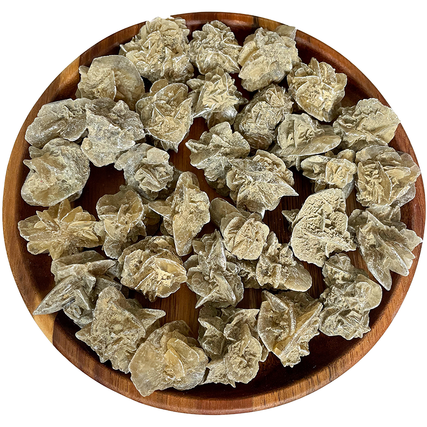 A collection of desert rose stones on a wood platter.