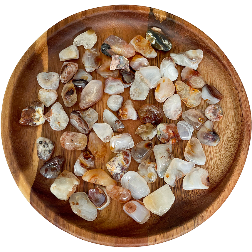 A collection of fire agate crystals on a wooden plate.