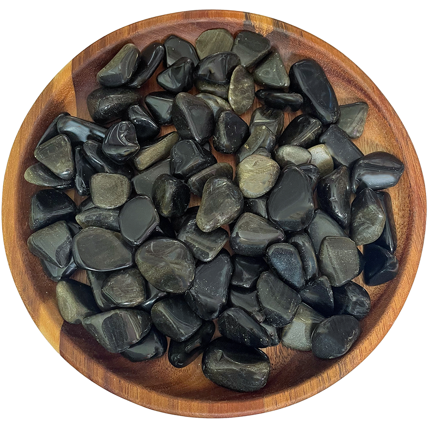 A collection of gold sheen obsidian stones on a wood plate.