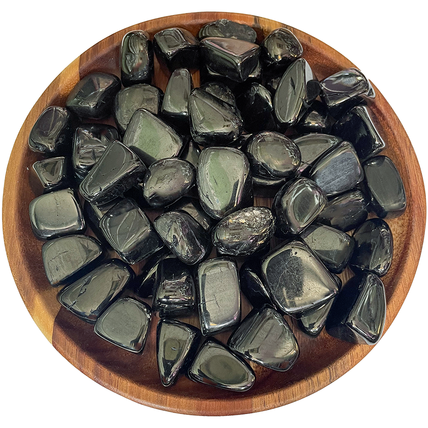 A collection of jet stones on a wood plate.
