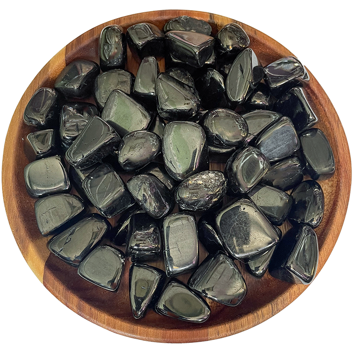 A collection of jet stones on a wood plate.
