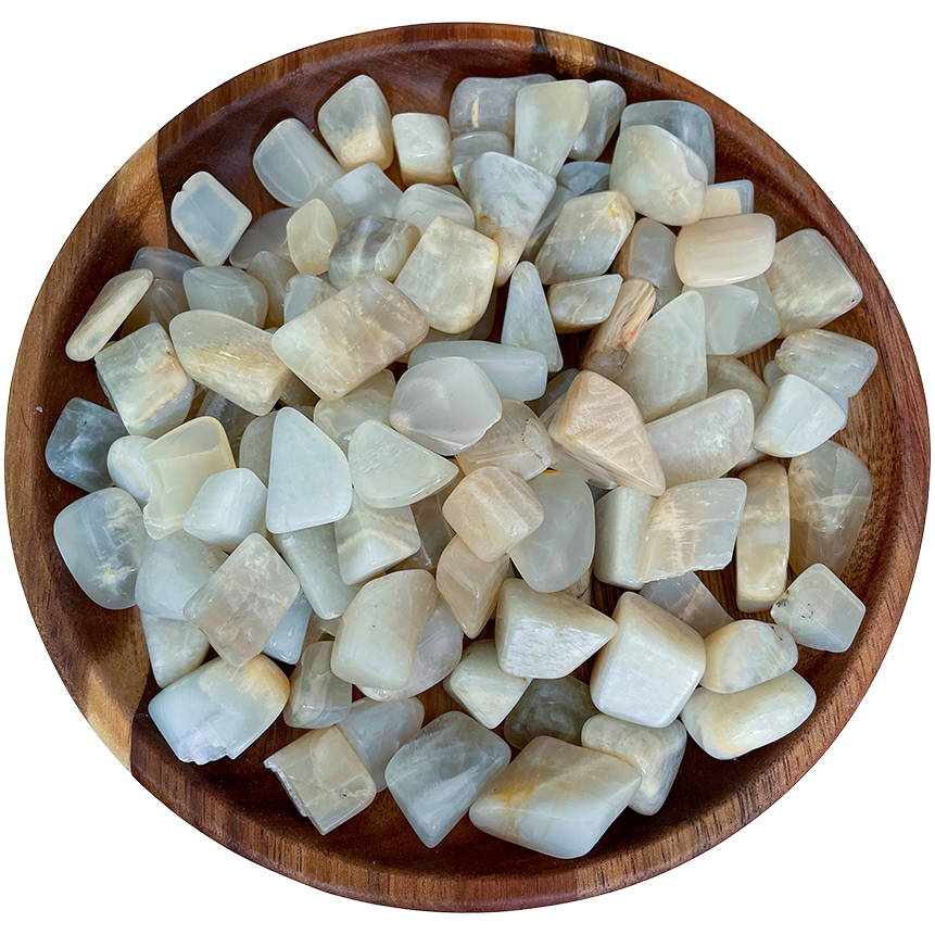 A collection of moonstone crystals on a wooden plate.