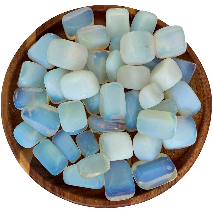 A collection of opalite stones on a wooden plate.
