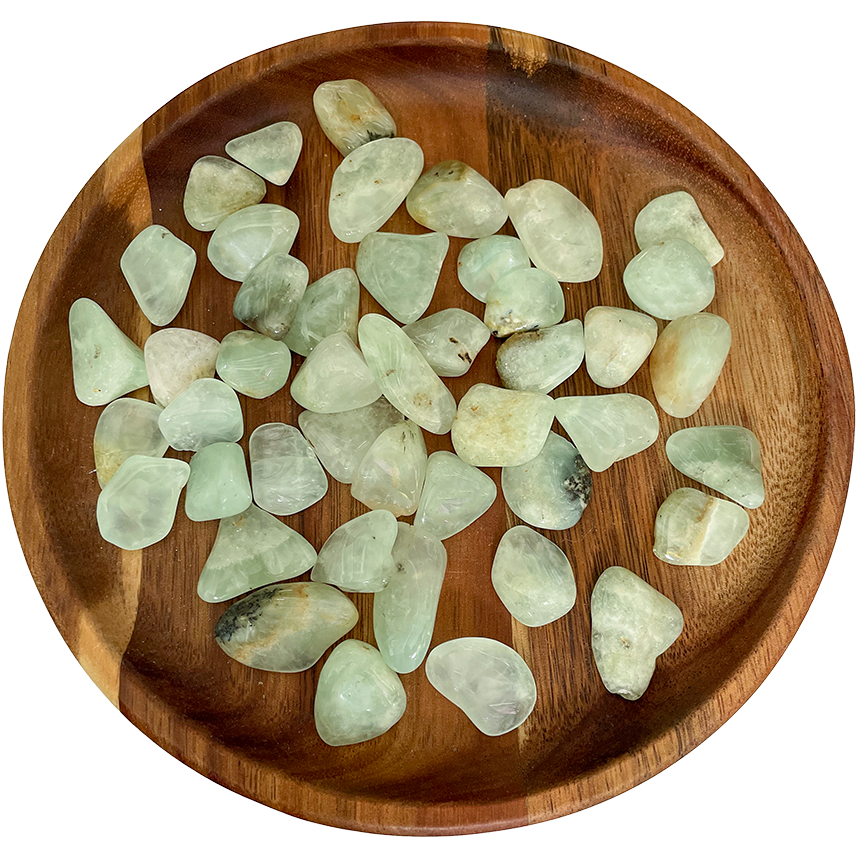 A collection of prehnite crystals on a wooden plate.