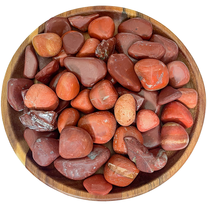 A collection of red jasper crystals on a wood plate.