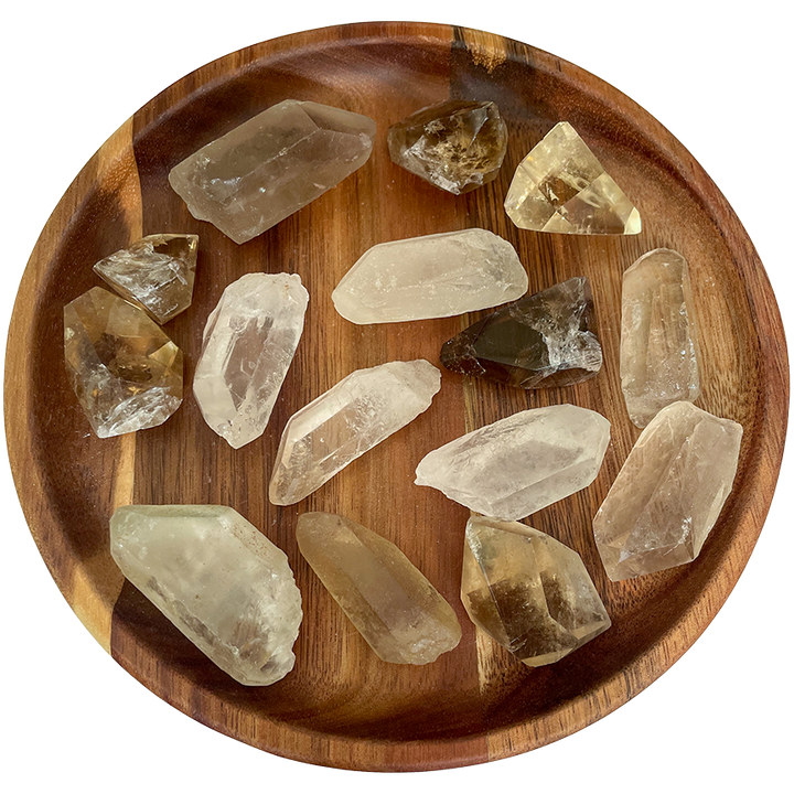 A collection with smokey quartz points on a wooden plate.