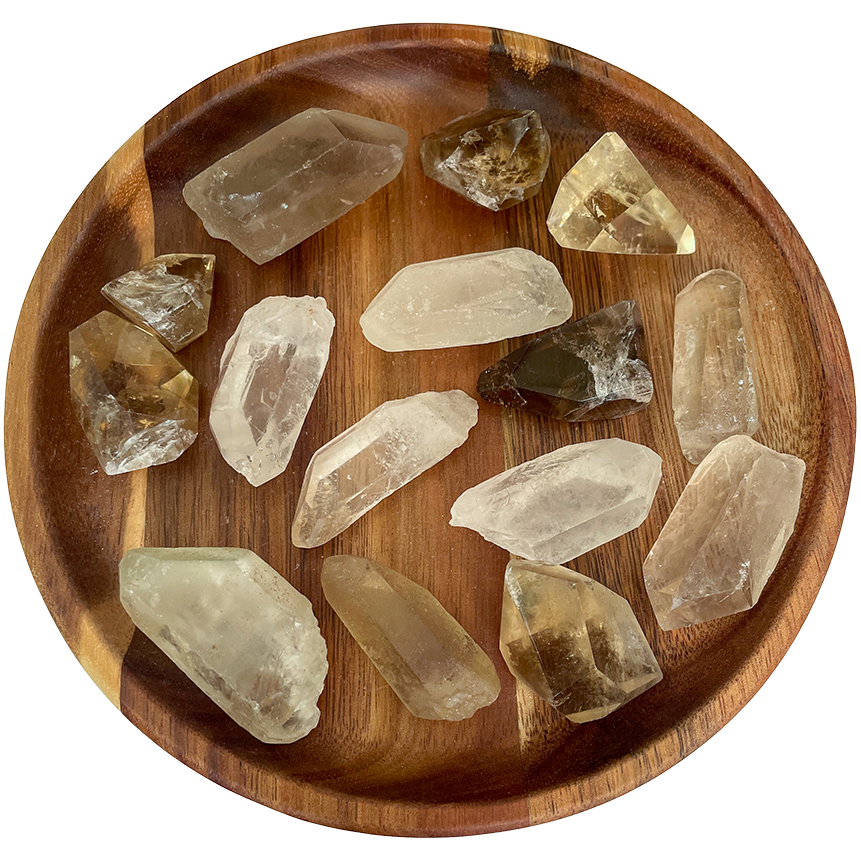 A collection with smokey quartz points on a wooden plate.