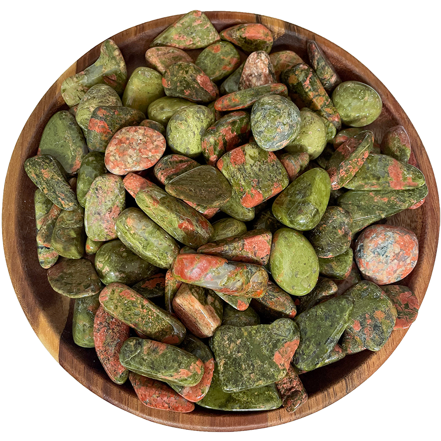 A collection of unakite stones on a wooden plate.